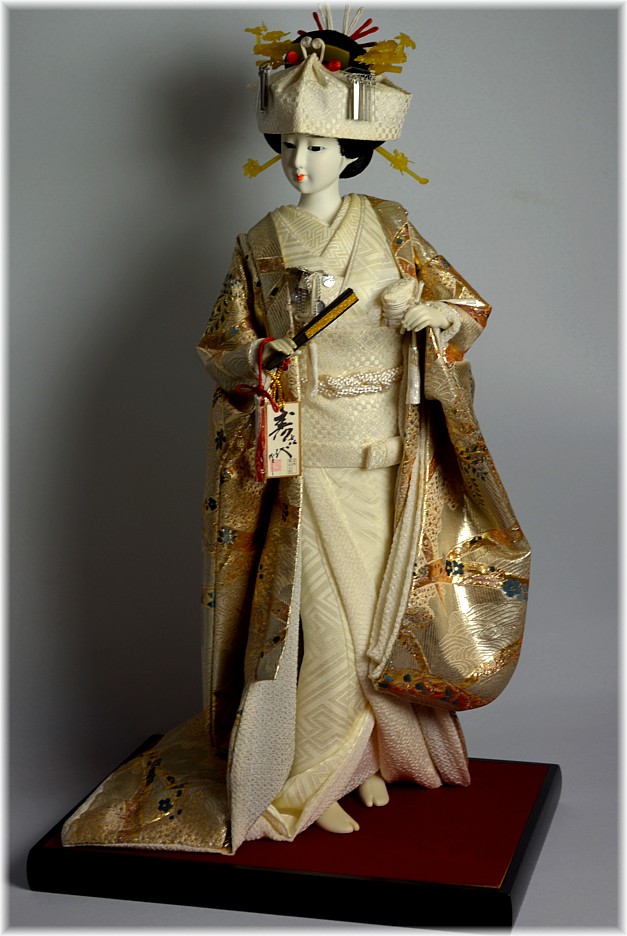 japanese doll with wedding kimono and with fan in her hand