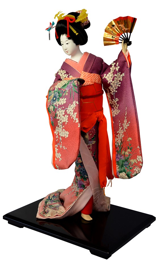 japanese traditional doll of a young woman dancing with folding fan in her hand