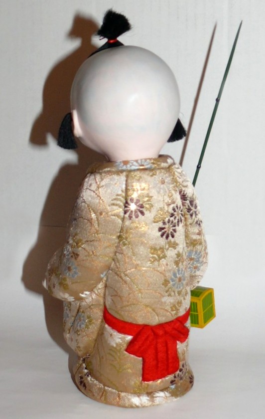 japanese kimekomi doll of a boy with twig
