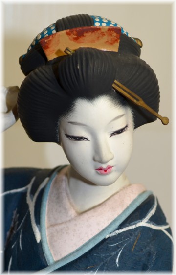Japanese traditional ceramic doll of a woman in dark blue kimono